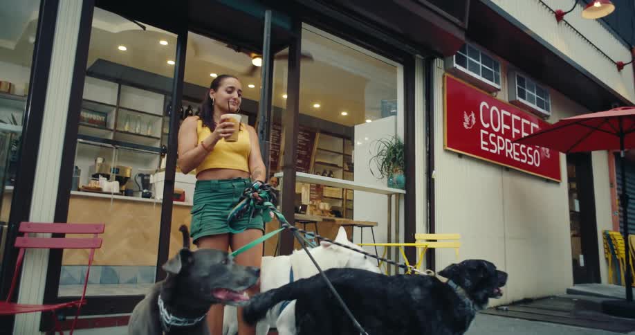 Woman leaving an establishment having a drink and with her four dogs on a leash