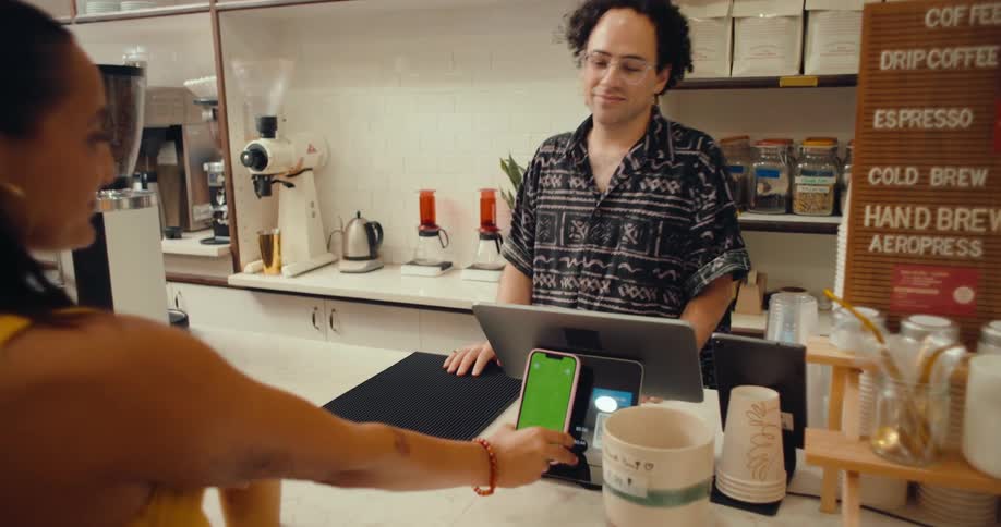 Woman getting a drink in a store and paying via cell phone