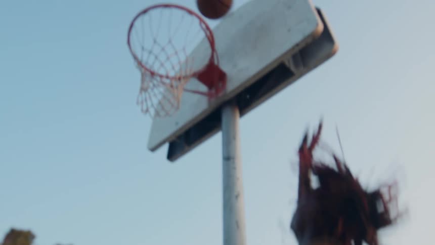 Boy running on a court and throwing a basketball into the basket