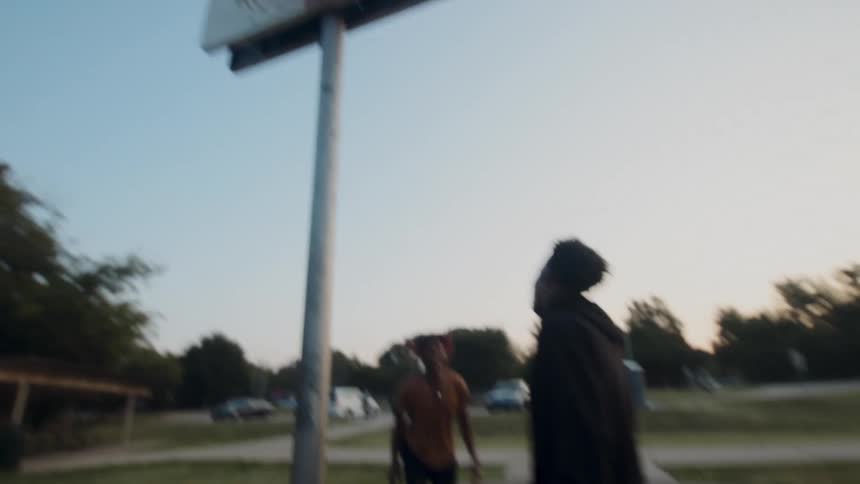 A man throws a basketball to another man and he runs to the basket and makes a dunk