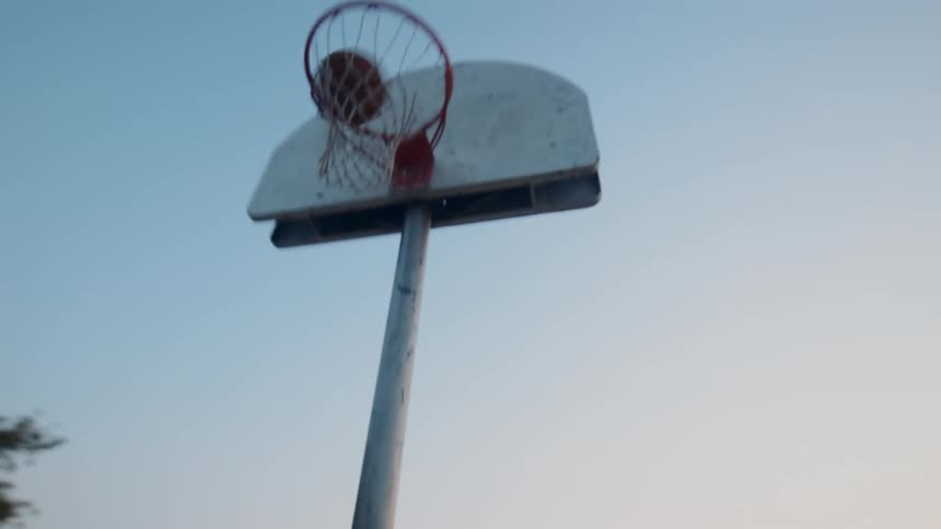 Two young men on a basketball court practicing shooting