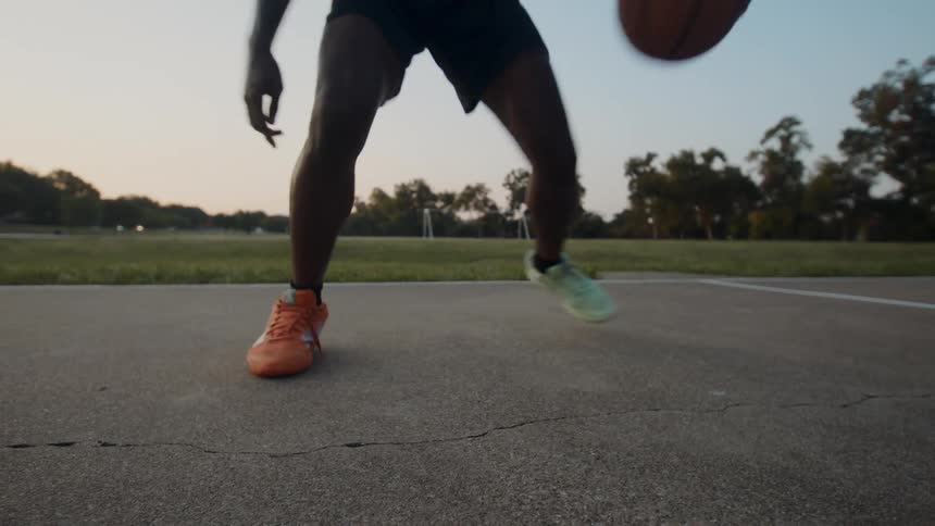 Boy doing skills with a basketball on a court