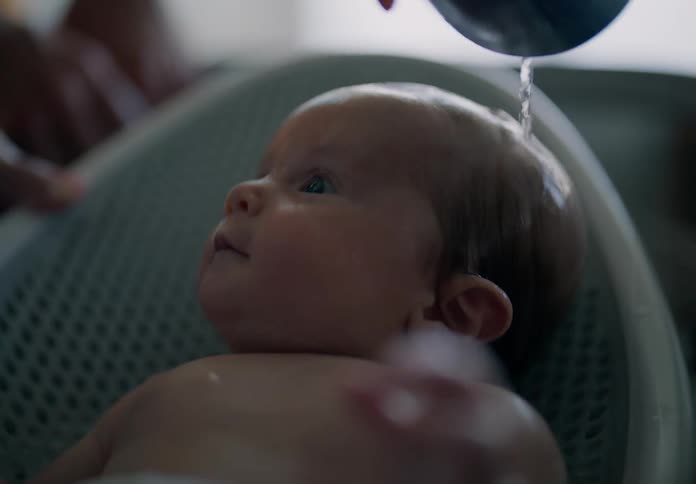 Close up of a baby being bathed on a small tub