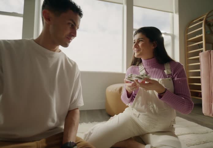Man and woman look at baby shoes before kissing each other