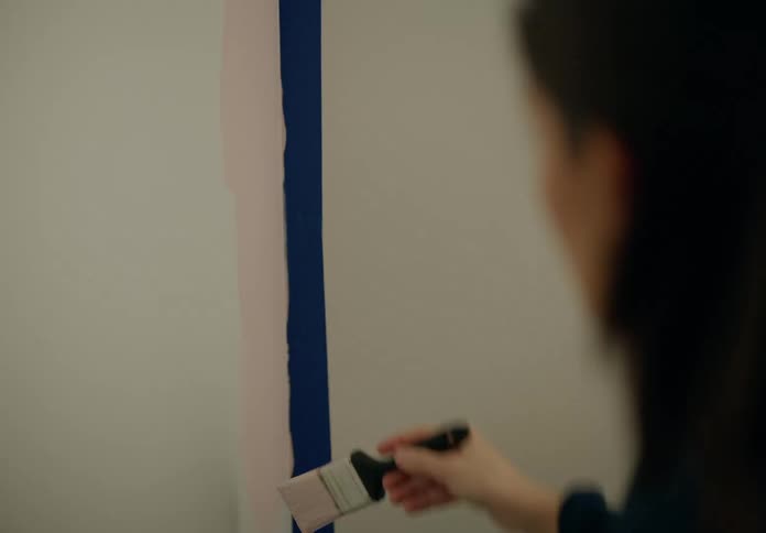 Portrait of a woman painting a bedroom wall