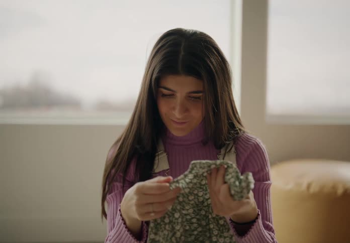 Man and woman sort baby clothes while talking to each other