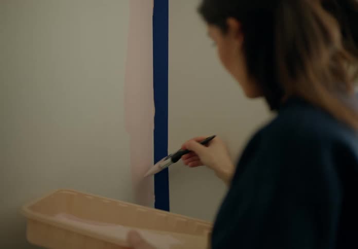 Woman with a paintbrush painting the wall of a room