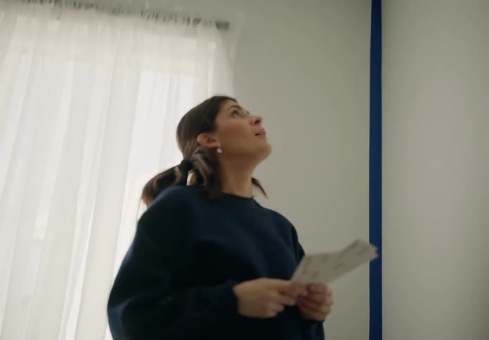 A young couple examines color swatches to find a match for the paint on their bedroom walls
