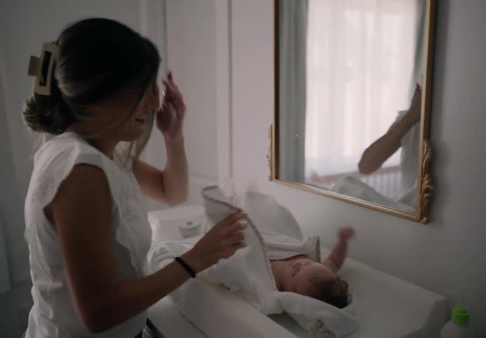 Mother laying her baby down next to a mirror