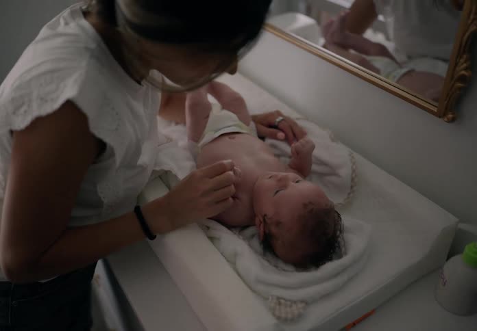Mother next to her newborn baby who is lying down
