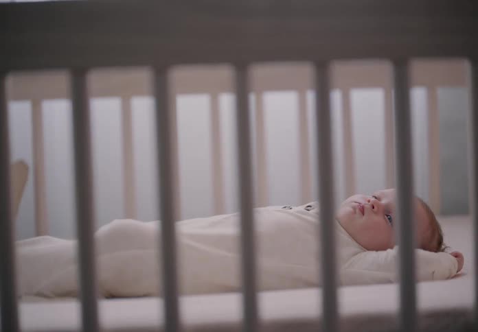 Closeup of a baby resting in a crib inside the bedroom