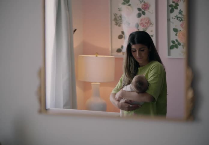 Mirror view reflecting mother holding baby in her arms
