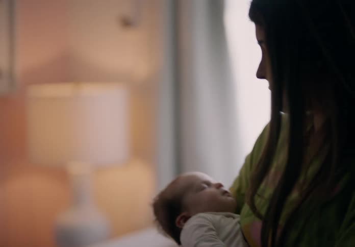Mother walking around the room with her newborn baby in her arms