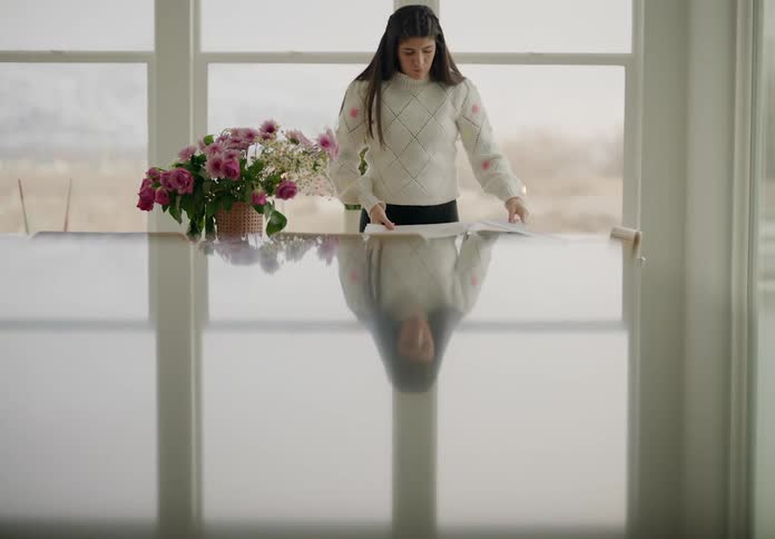 Woman standing next to a table with books and flower