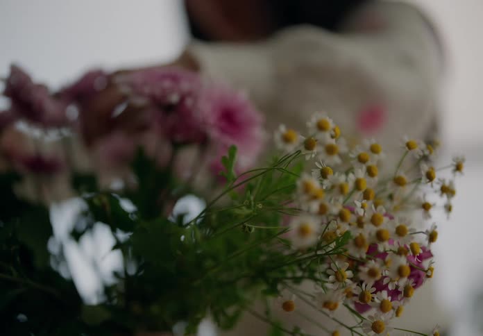 A woman is arranging a flower bouquet