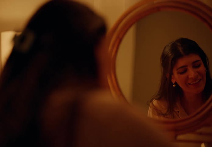 Woman sitting in front of a round mirror