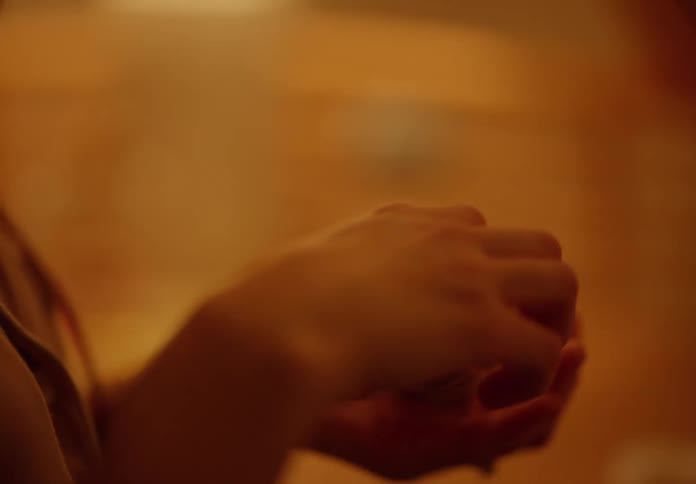 A woman takes a bottle of pills from the nightstand