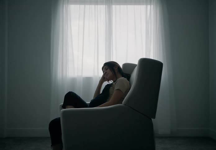 Bored pregnant woman sitting in an armchair
