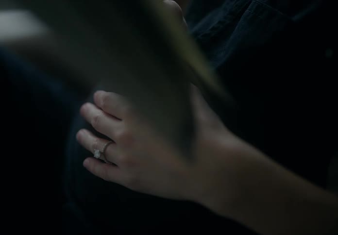 Close up of the hand of a pregnant woman resting over her waist