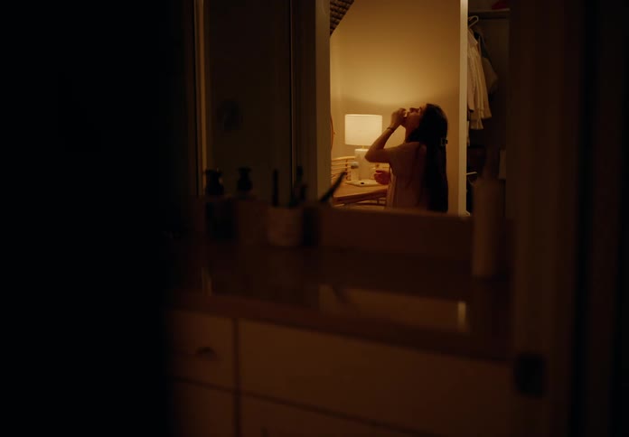 Woman sitting taking a capsule and doing skin care