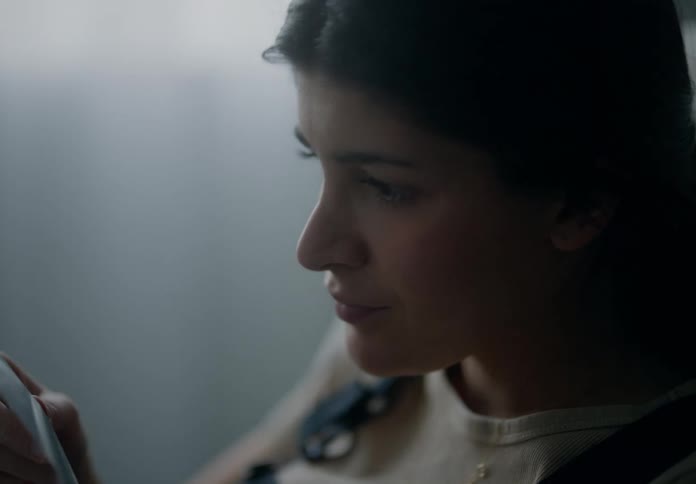 Closeup of the face of a woman reading inside a dimly lit room