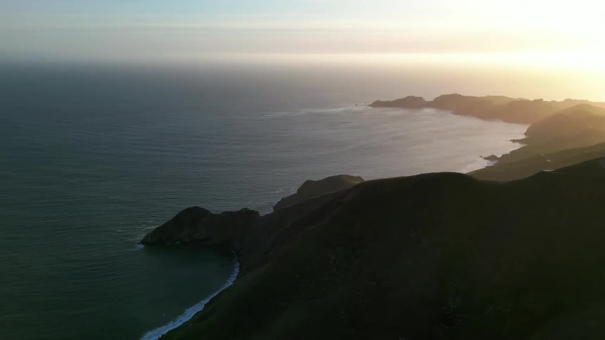 Aerial scene of rocky mountains surrounded by sea in a morning sky