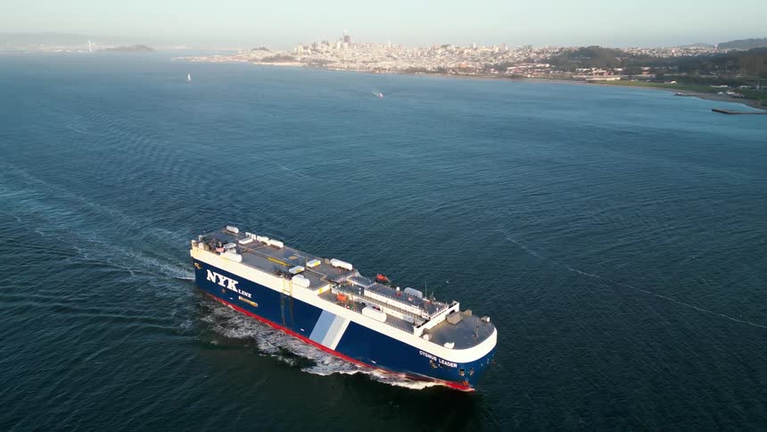 A cargo ship travels towards the bridge full of traffic
