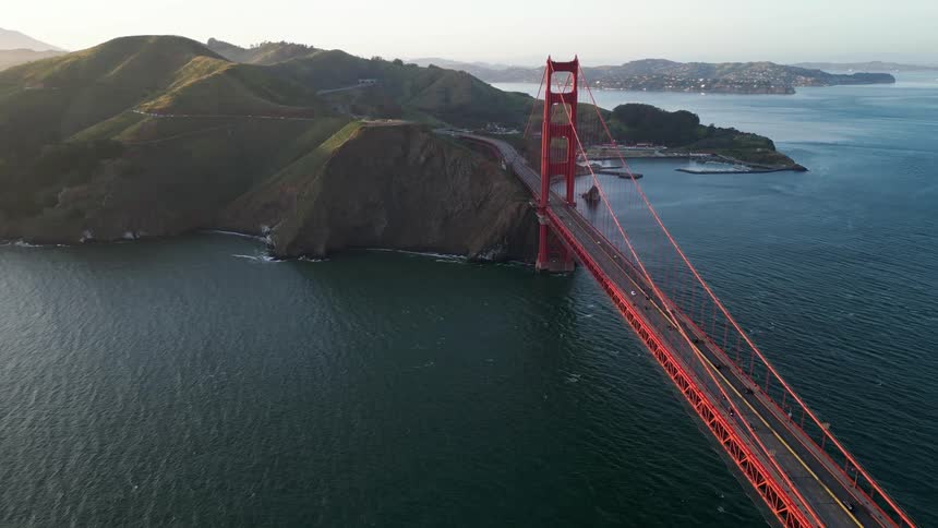 Aerial view of a red bridge above a sea with vehicle traffic