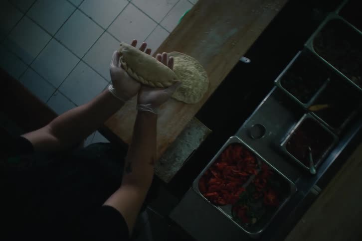 Woman holding a fresh puff pastry dough and placing it on a countertop