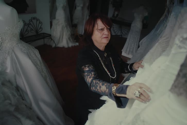 A woman is looking at wedding dresses in the shop