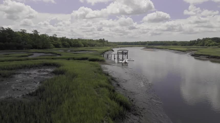 Aerial view of a river and a pier in the background