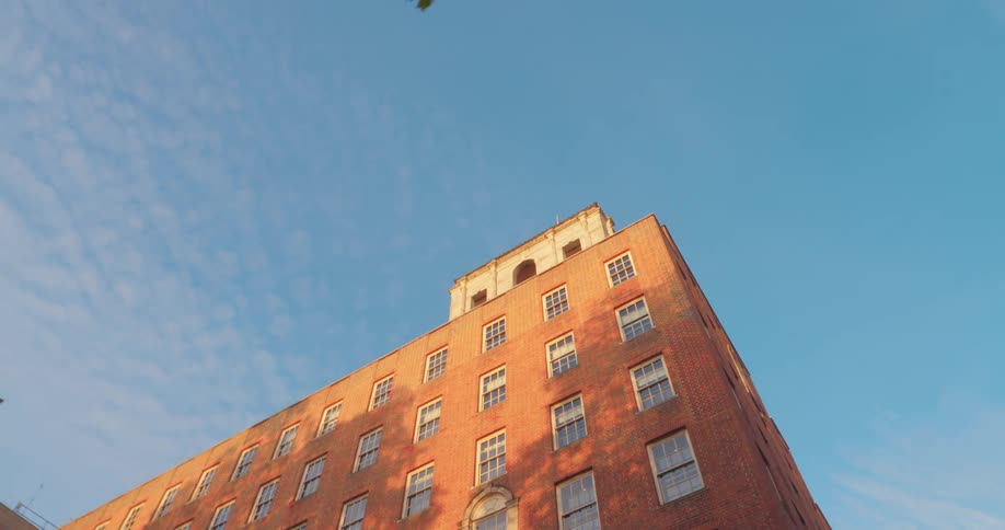Upward view of urban buildings against a blue sky