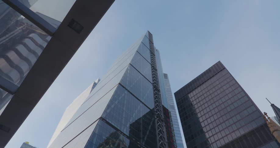 A huge skyscraper building with its exterior full of glass reflecting the surroundings