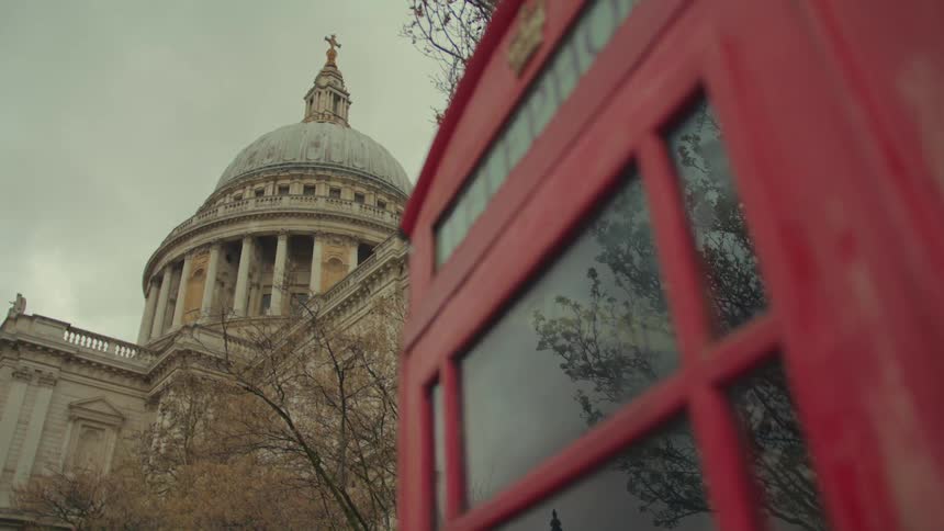 St pauls cathedral from a low angle point seen behind a red phone booth