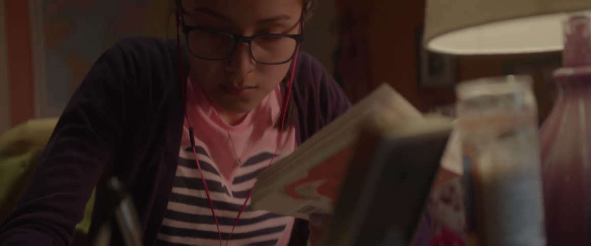 A girl in glasses writes in a notebook