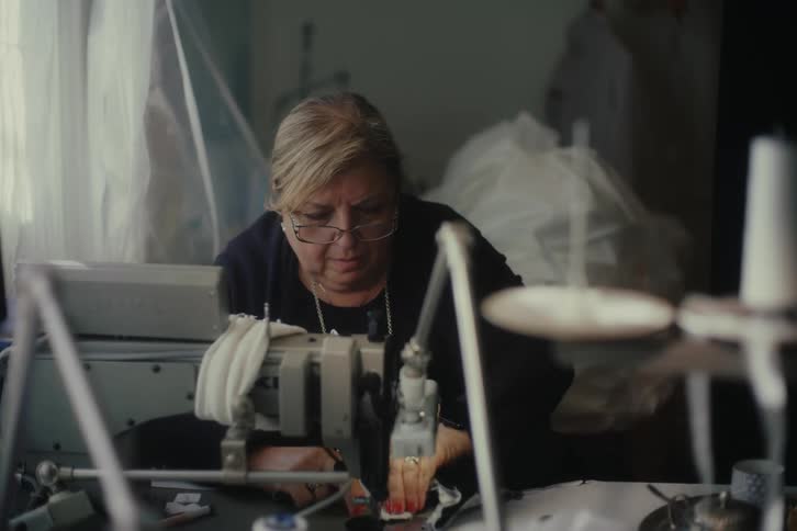 A seamstress operating a sewing machine in a workshop
