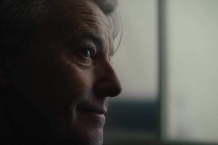 A man smiles in the dark room