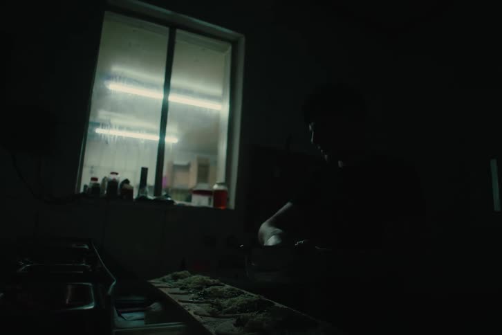 A man is preparing food in the dark