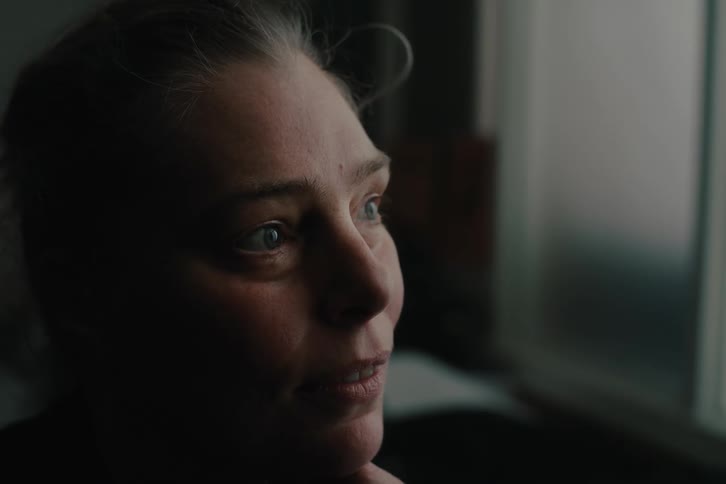 The face of a woman who is looking forward and then opens a smile