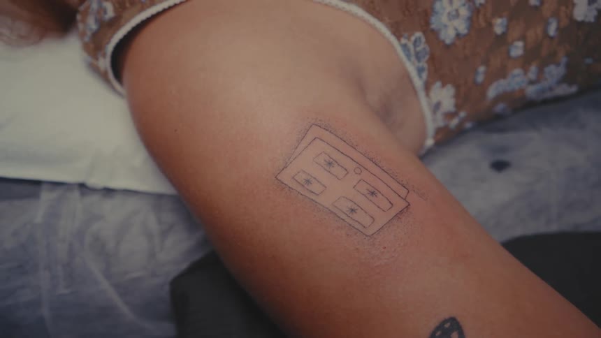 A closeup of a persons arm with a tattoo stencil featuring a door