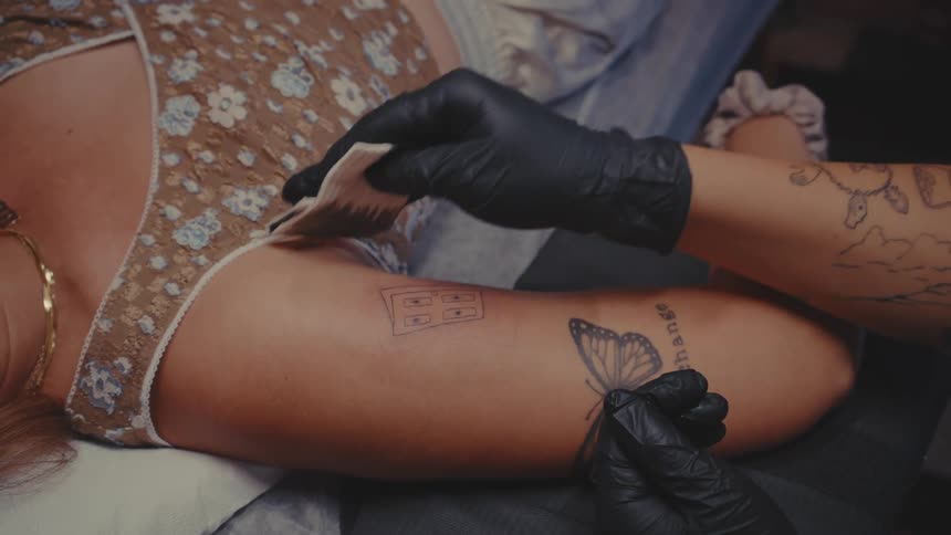 Tattoo artist cleaning clients arms