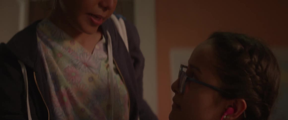 Woman talking to young girl in bedroom
