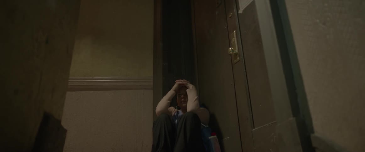 Woman slides down to the floor and rests head on her hands