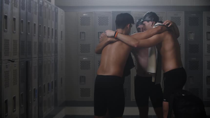 A group of swimmers huddle before the competition in the locker room