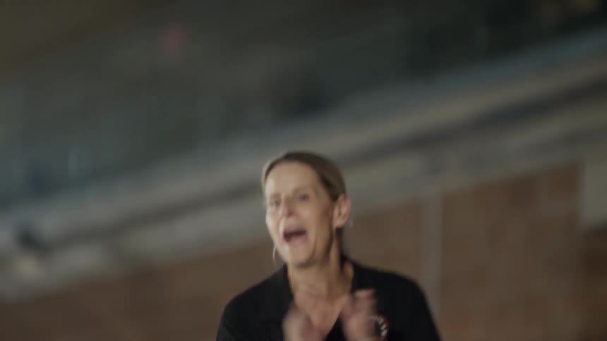 A woman walks and claps while cheering