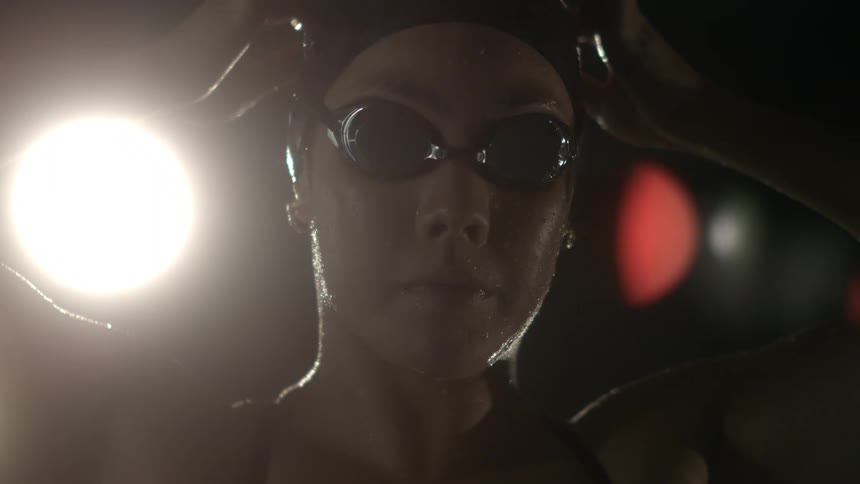 Portrait of a young woman adjusting swimming goggles