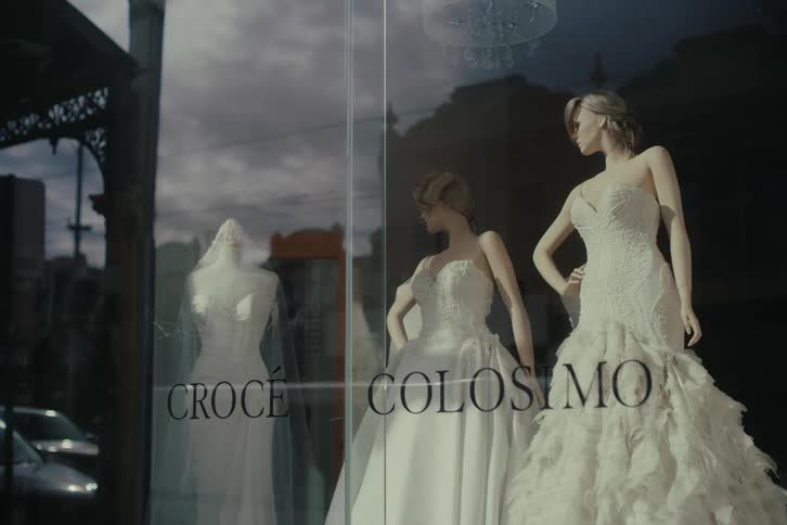 Two white wedding dresses on mannequins in a glass showcase