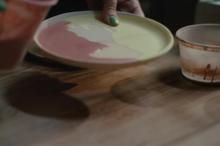 Hand pouring paint into a plate