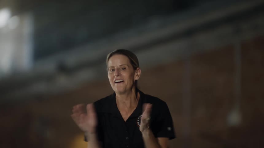 Woman running next to a swimming pool clapping and cheering