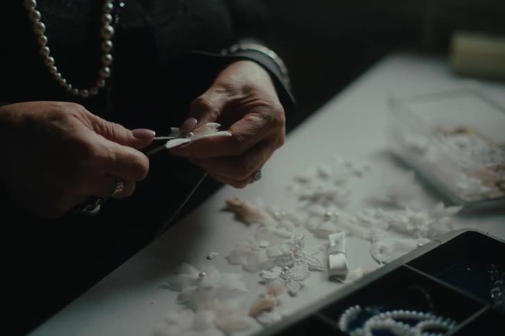 A woman making flowers into jewelry